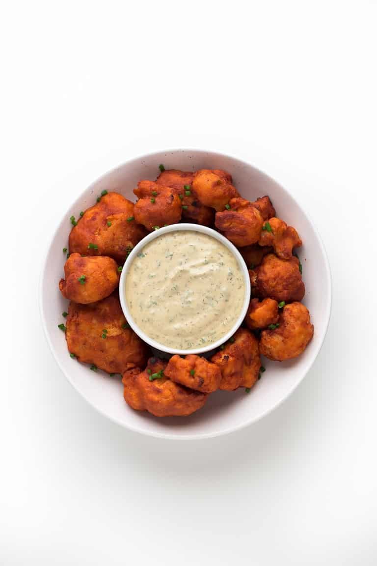 Photo of a bowl of buffalo cauliflower wings taken from the above