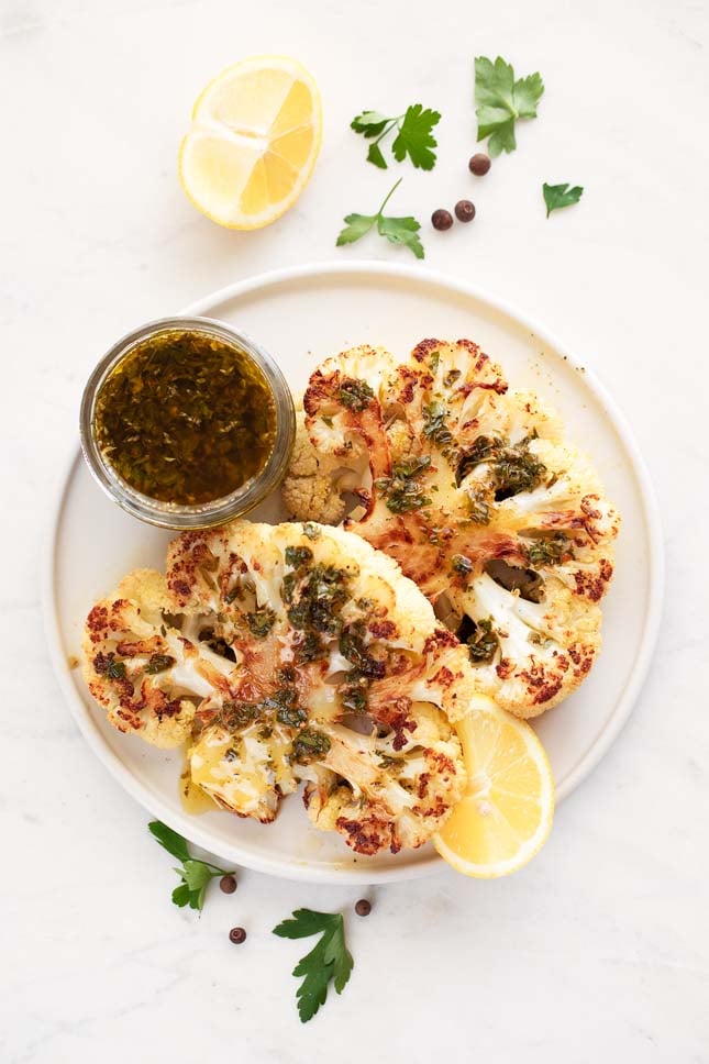 Photo of 2 cauliflower steaks with chimichurri sauce on top