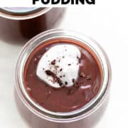 Glass of vegan chocolate pudding topped with whipped cream and chocolate shavings.