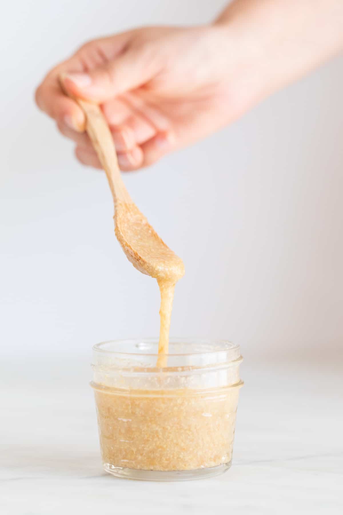 A spoon lifting some flax seed mix from a small container.