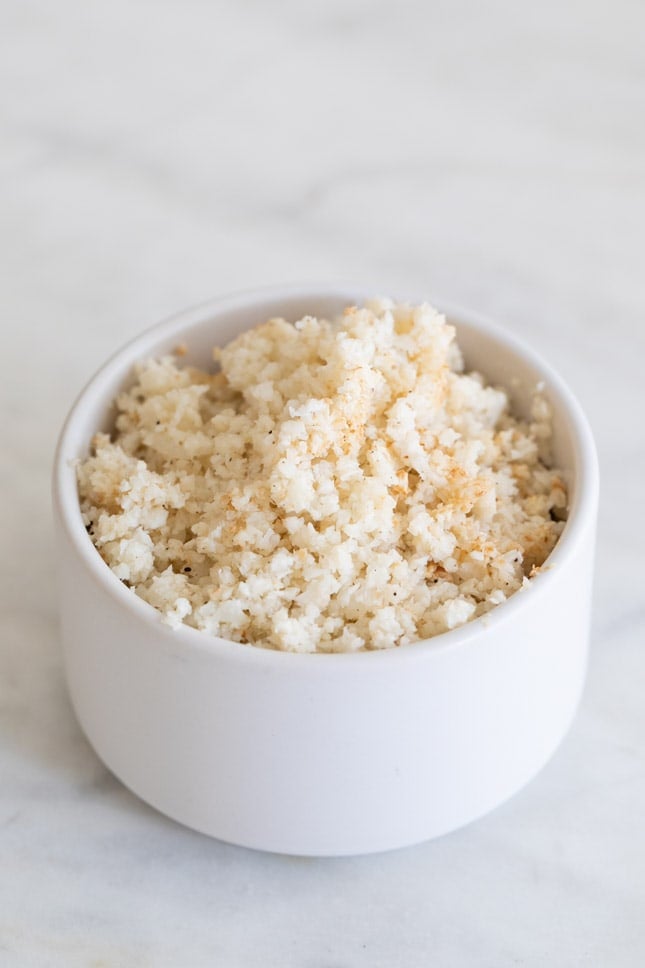 An overhead shot of a small bowl with sautéed cauliflower rice