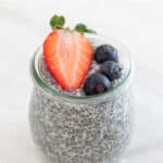 A jar with chia pudding and topped with berries.