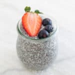 A jar with chia pudding and topped with berries.