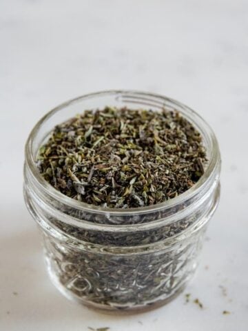A close shot of a glass jar with homemade Italian seasoning