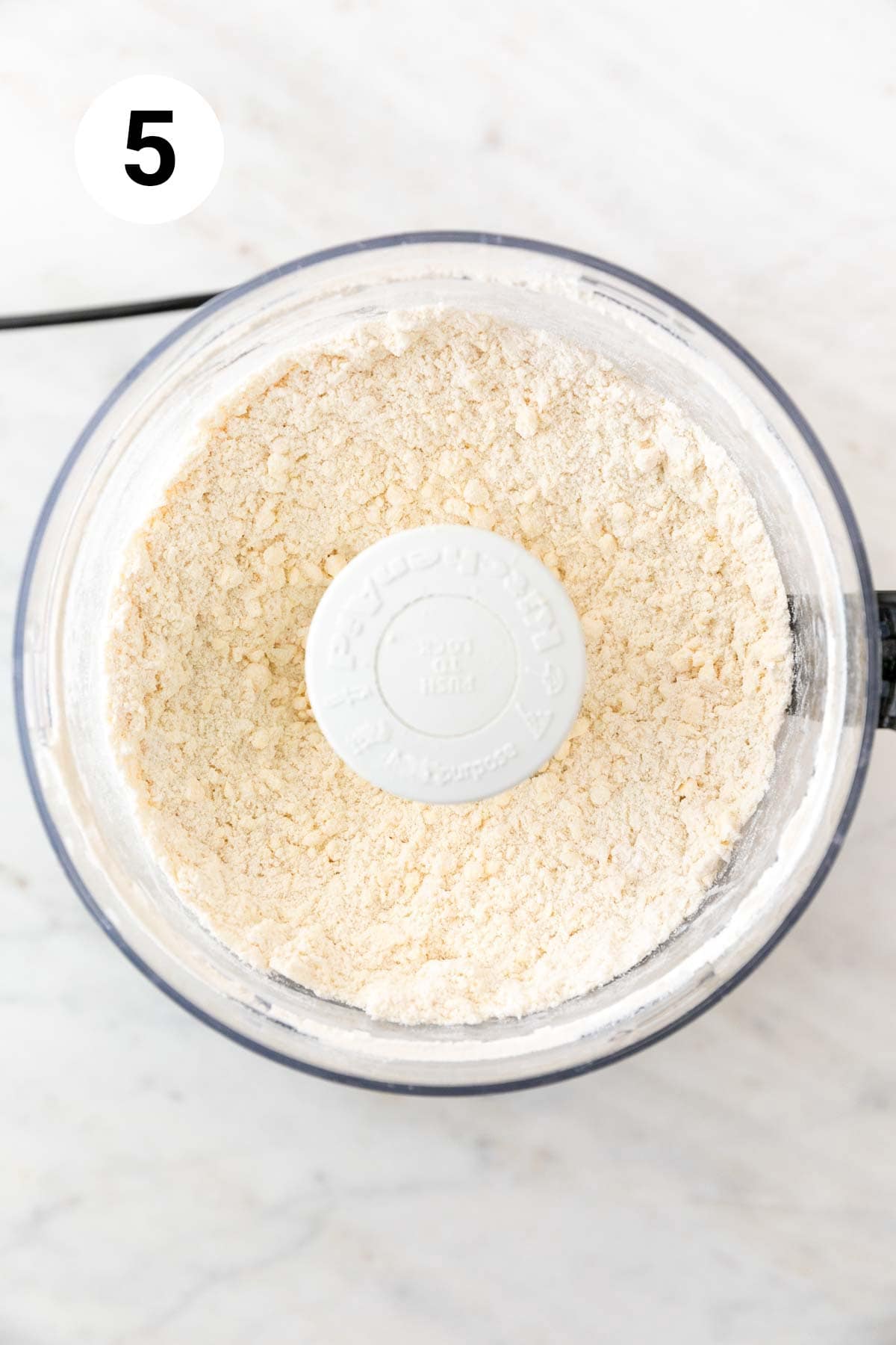 Dry ingredients mixed with the vegan butter in a food processor.