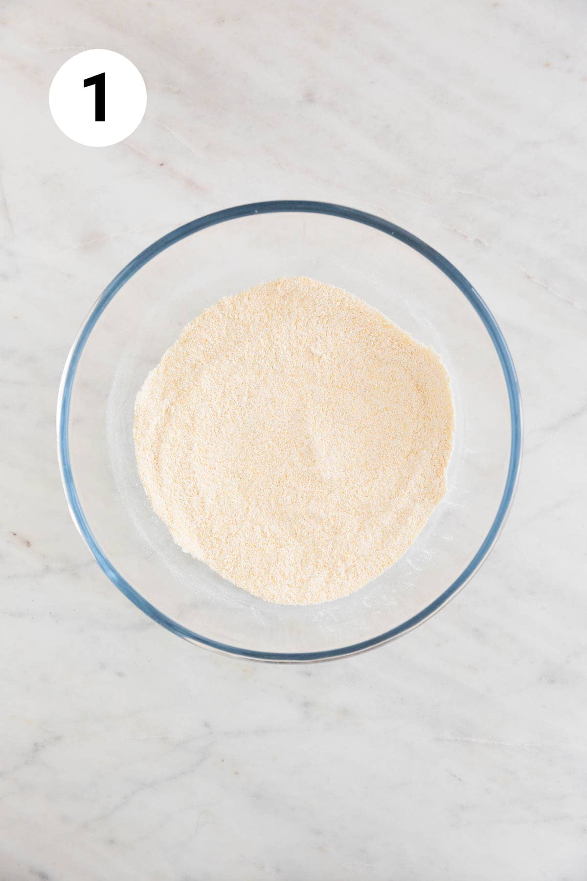 A large bowl with the dry ingredients to make vegan cornbread mixed.