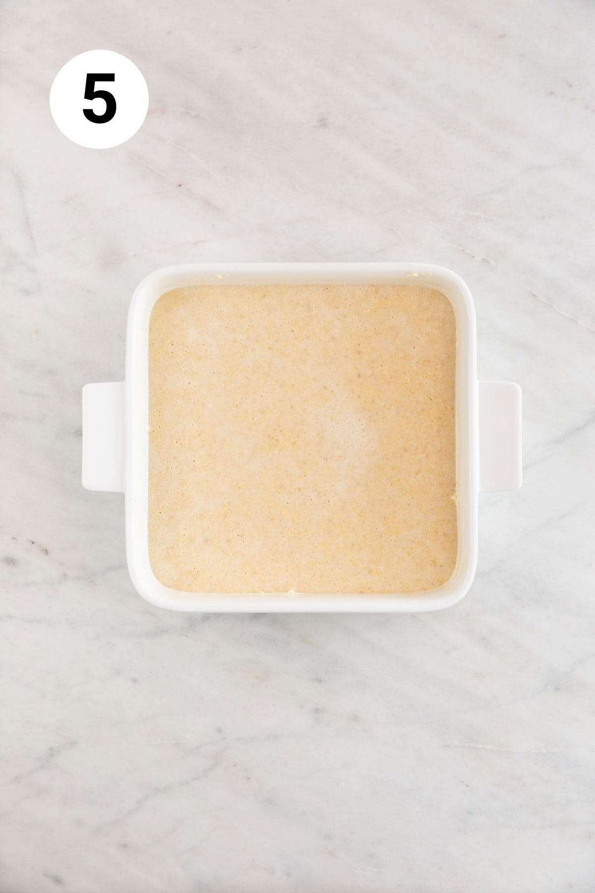 Vegan cornbread batter in a square baking dish.