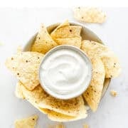 Vegan sour cream dip served with crispy tortilla chips.