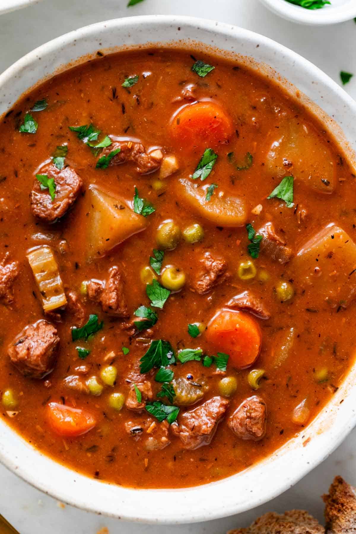 Vegan beef stew served in a bowl with parsley on top.