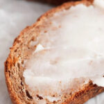 Photo of some vegan butter spread onto a slice of vegan bread with a heading