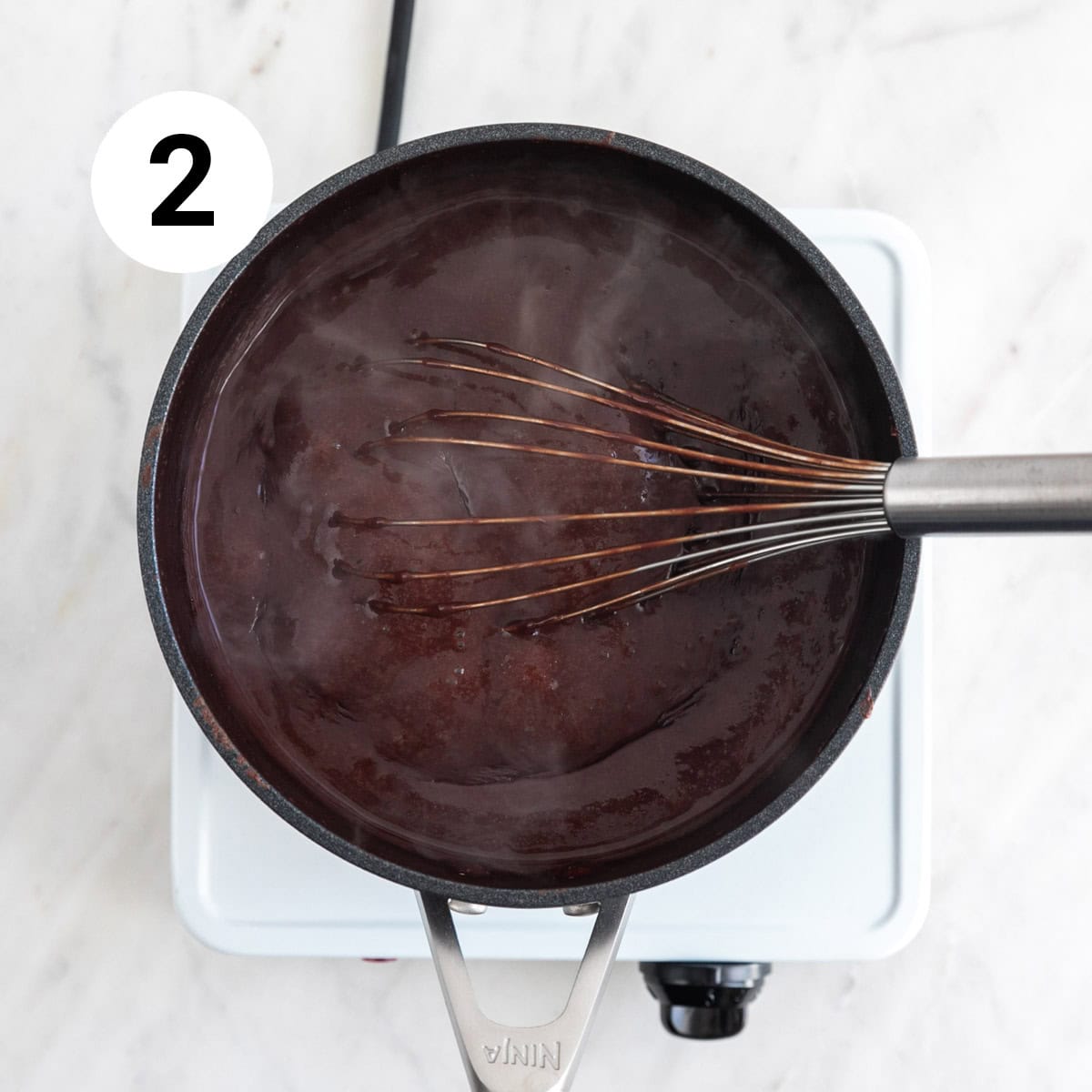 Cooking vegan chocolate pudding in a saucepan on stovetop.
