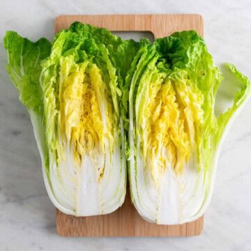 Cabbage cut in half on a cutting board.