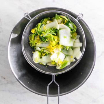 Cabbage in a strainer after rinsing to remove excess salt.