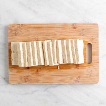 Sliced tofu on a wooden cutting board.