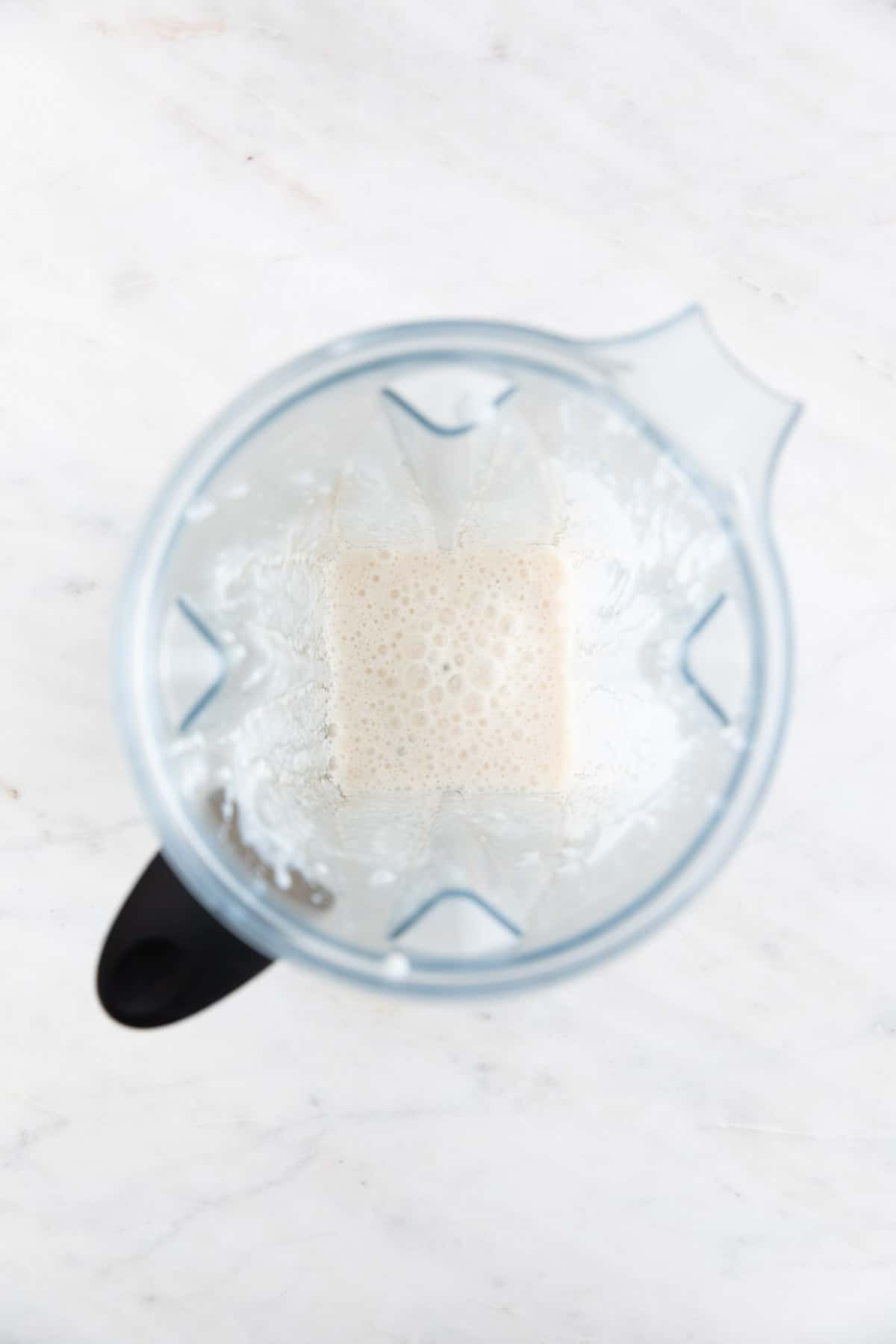 A high-speed blender with all the vegan mayonnaise ingredients blended except the oil.