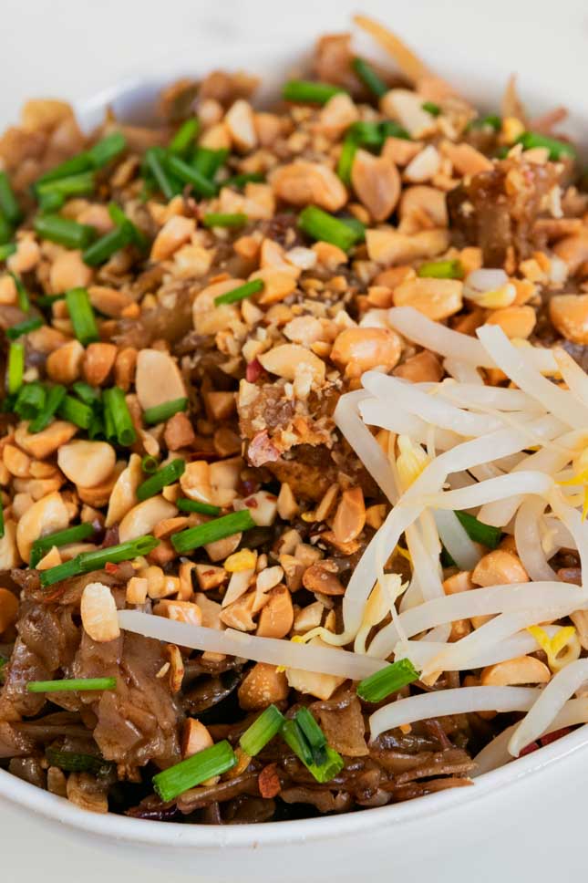 A close shot of a bowl of vegan pad Thai with tofu