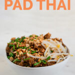 A picture of a bowl with homemade vegan pad Thai with toppings with the words vegan pad Thai