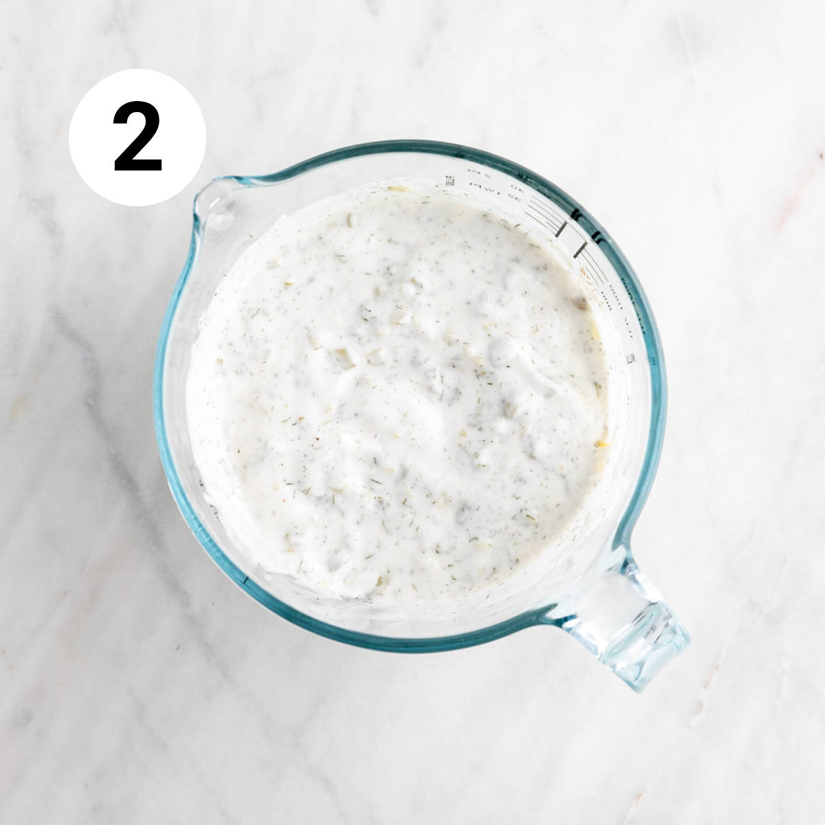 Measuring cup with vegan tartar sauce.